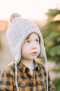 Toddler wearing winter hat looks up magical, holiday, thoughtful