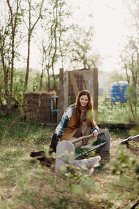 Smiling woman holding hen at farm