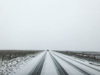 Snow covered road against sky