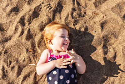 High angle view of cute baby girl on sand