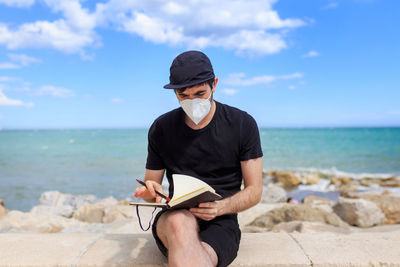 Young man sitting on beach