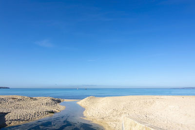 Scenic view of beach against blue sky