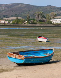 Abandoned boat moored on beach