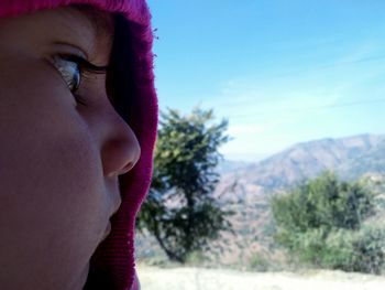 Close-up portrait of teenage girl on field against sky
