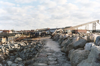 Bridge over rocks in city against sky