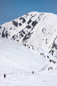 People on snowcapped mountain against sky