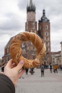 Tourist woman eating bagel obwarzanek traditional polish cuisine snack waling on market square st