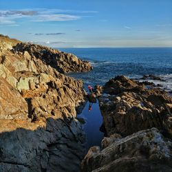 Rock formations by sea against sky