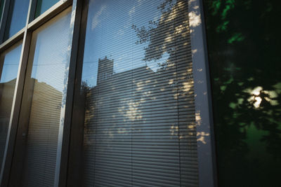 Low angle view of building seen through glass window