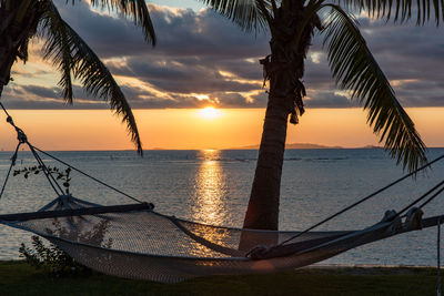 Scenic view of sea against sky during sunset with hammock 