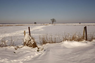 Scenic view of snow covered land against sky