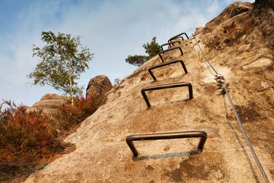 Climbers ladder. iron twisted rope fixed in block by screws snap hooks. rope end anchored into rock.