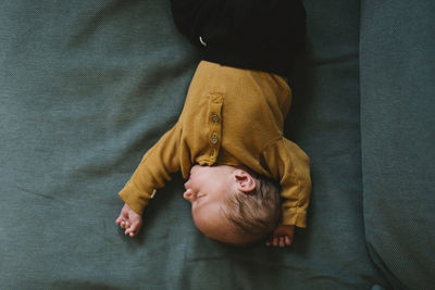 High angle view of man sleeping on bed