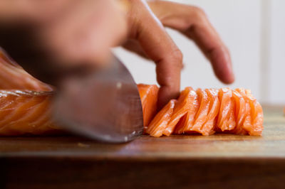 Cropped hand of person chopping meat