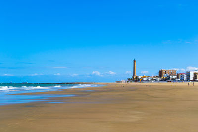 Scenic view of beach against blue sky