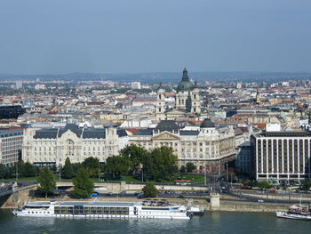 River amidst buildings in city against clear sky