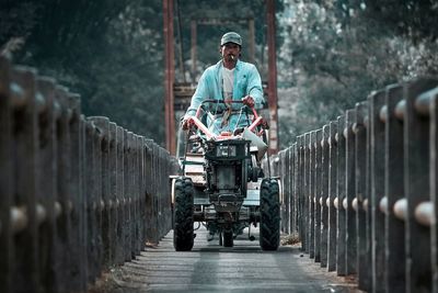 Portrait of man riding tractor on road