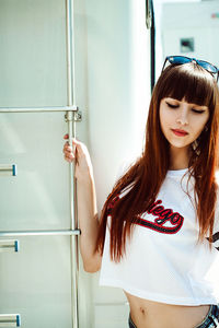 Young woman standing by camper trailer