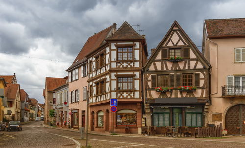 Residential buildings by street against sky