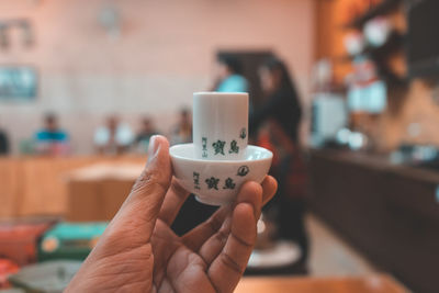 Close-up of hand holding coffee cup