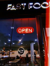 Low angle view of illuminated neon sign at night