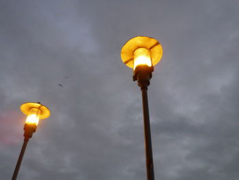 Low angle view of illuminated street light against sky