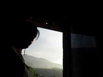 Portrait of man looking through window