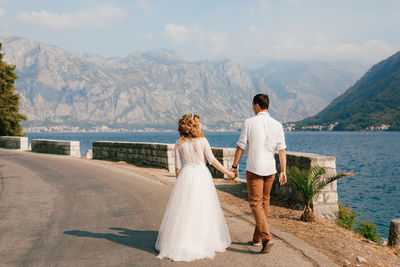 Rear view of couple kissing against mountains