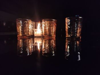 Close-up of glasses on table against black background