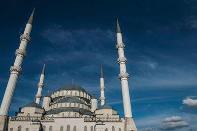 Low angle view of mosque against cloudy sky in turkey
