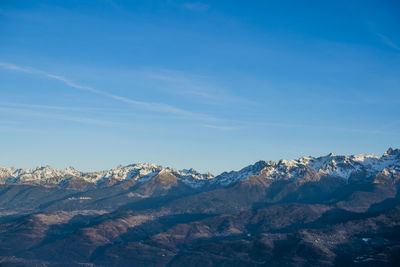 Scenic view of snowcapped mountains against blue sky