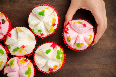 Cropped hand of person holding dessert on table