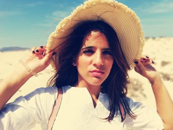 Portrait of young woman with hat on beach