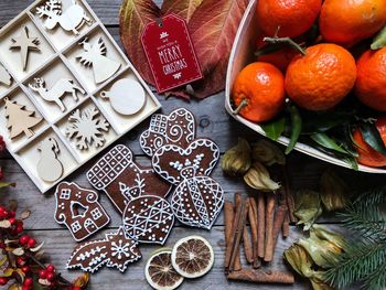 High angle view of christmas cookies with fruits and spices on table