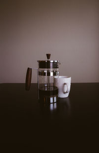 Coffee in jug against wall on table