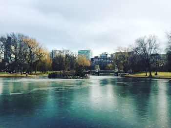 Scenic view of river by city against sky