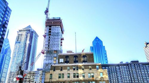 Low angle view of buildings against clear blue sky