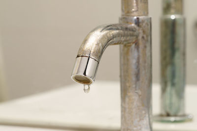 Close-up of water drop dripping from faucet