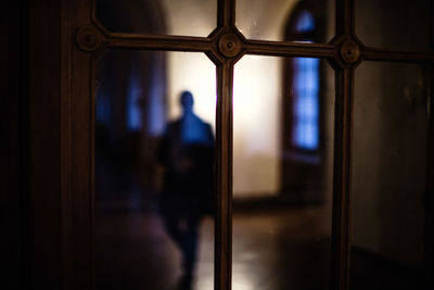 Reflection of man on glass window of building