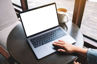 Midsection of man using laptop on table