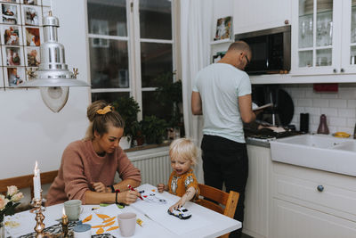 Rear view of mother and daughter on table