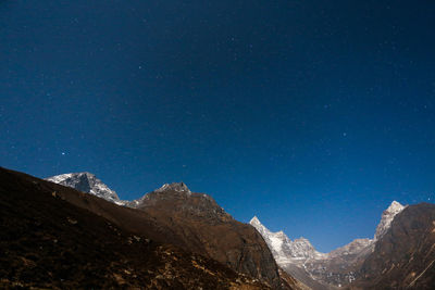 Scenic view of mountains against clear blue sky