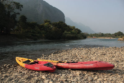 Scenic view of river by mountains against sky