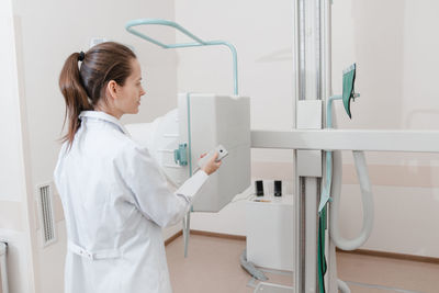 Rear view of doctor using hand sanitizer at bathroom