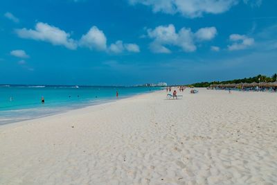 People at beach against sky