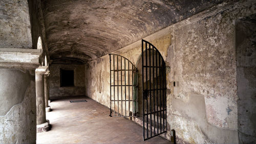 Open gate in corridor of old prison