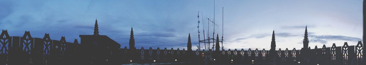 sky, built structure, architecture, cloud - sky, building exterior, low angle view, cloud, silhouette, dusk, blue, city, cloudy, outdoors, panoramic, travel destinations, no people, fence, day, industry, factory