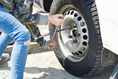 Low section of man repairing car