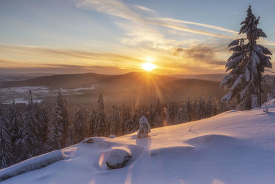 Scenic view of snow covered landscape against sky during sunset