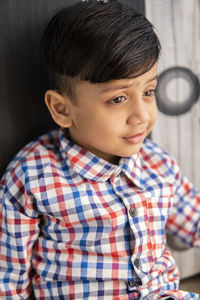 Cute boy looking away while sitting at home